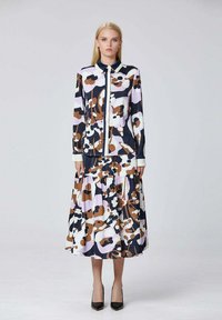 Robe à manches longues arborant un motif floral coloré dans des teintes de rose, marron et marine, avec un col et une jupe à volants.