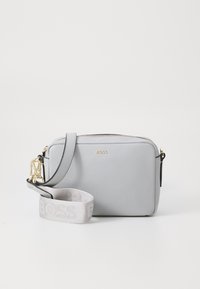 Borsa a tracolla grigia in pelle con dettagli in oro, chiusura con zip e tracolla removibile con il nome del marchio in rilievo.