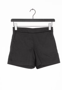 Black shorts with a smooth texture, featuring a mid-rise waist, side pockets, and a clean hem. Hung on a metal hanger.