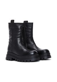 Botas de piel negra hasta el tobillo con suela de goma gruesa, cremallera lateral, detalle acanalado y tira de agarre para facilitar la puesta.