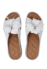Hvide lædersandaler med en struktureret brun indersål. Hver sandal har en dekorativ, lagdelt blomsteraccent på den øverste del.