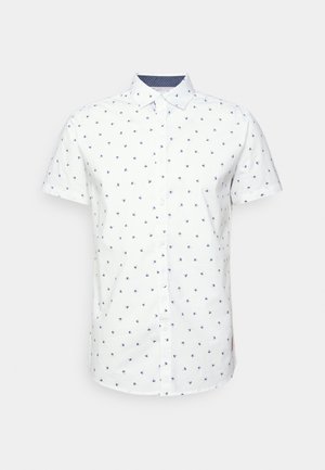 White short-sleeve shirt with a navy pattern of small floral motifs. Button-up design, collar, and contrasting navy inner lining.
