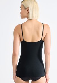 Canotta nera con spalline sottili, realizzata in un materiale morbido e elastico. Presenta un design aderente e un orlo dritto in vita.