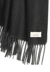 Fular negru din lână, cu margini franjurate și un eticheta albă cu numele brandului "Dstrezzed". Textură moale. Formă rectangulară.