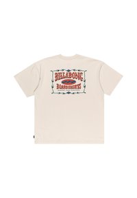 Cream-colored t-shirt featuring large, colorful “BILLABONG BOARDSHORTS” logo on back with decorative border and wave design. Short sleeves.