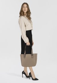 Beige Leder-Shopper mit doppelten Griffen, ausgestattet mit subtilen Nähten und silbernen Hardware-Akzenten. Glatte Textur, strukturierte Silhouette.
