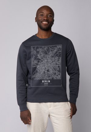 Dark navy sweatshirt featuring a white map print of Berlin, with text reading "BERLIN GERMANY" below the graphic. Smooth cotton material.