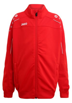 Veste de sport rouge avec fermeture éclair à l'avant, logo JAKO, accents blancs et perforations circulaires sur les épaules. Texture de tissu douce et lisse.