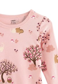 Vaaleanpunainen pitkähihainen paita ruskea korostus, jossa on leikkisä metsämotiivi, jossa on puita, eläimiä ja sieniä pehmeissä väreissä.