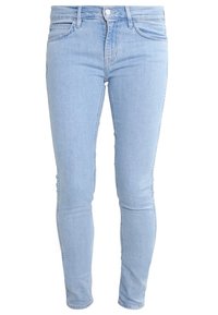 Jeans skinny de mezclilla azul claro con una textura suave, cinco bolsillos, pasadores para cinturón y un cierre de botón en la cintura.