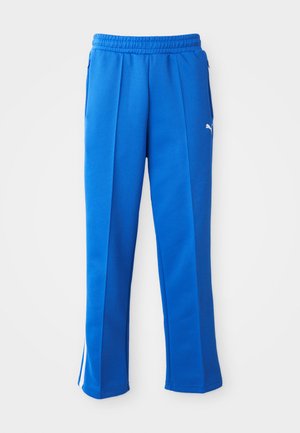 Pantaloni sportivi albaștri cu un brâu elastic, buzunare laterale și accente de dungi albe. Fabricati dintr-un material neted și elastic.