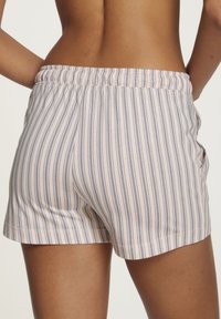 Keve pink shorts with navy vertical stripes, elastisk midja, sidofickor och en avslappnad passform. Slät textur och kort längd.