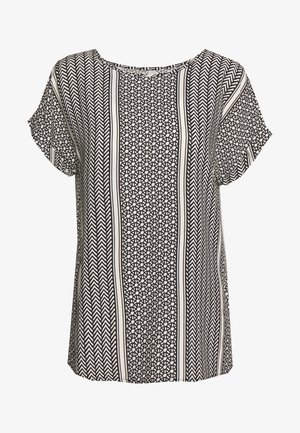 Sort og hvid mønstrede bluse med korte, let svajende ærmer, der har geometriske designs og lodrette striber i et let materiale.