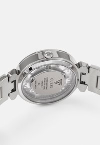 Kellon valmistettu ruostumattomasta teräksestä, jossa on pyöreä kuori, lasipohja, joka näyttää mekanismin yksityiskohtia, ja päivämääränäyttö. Sivulla on kruunu.