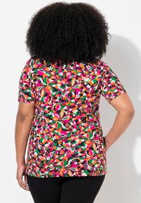 Barevný bavlněný top s krátkým rukávem, který má květinový a abstraktní vzor v růžové, oranžové, zelené a černé barvě. Volný střih.