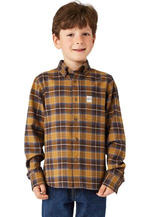 Braun-gelbes karierte Flanellhemd mit Knopfleiste und Kragen. Verfügt über ein kleines Logo-Patch. Wird von einem Kind getragen, kombiniert mit blauen Jeans.