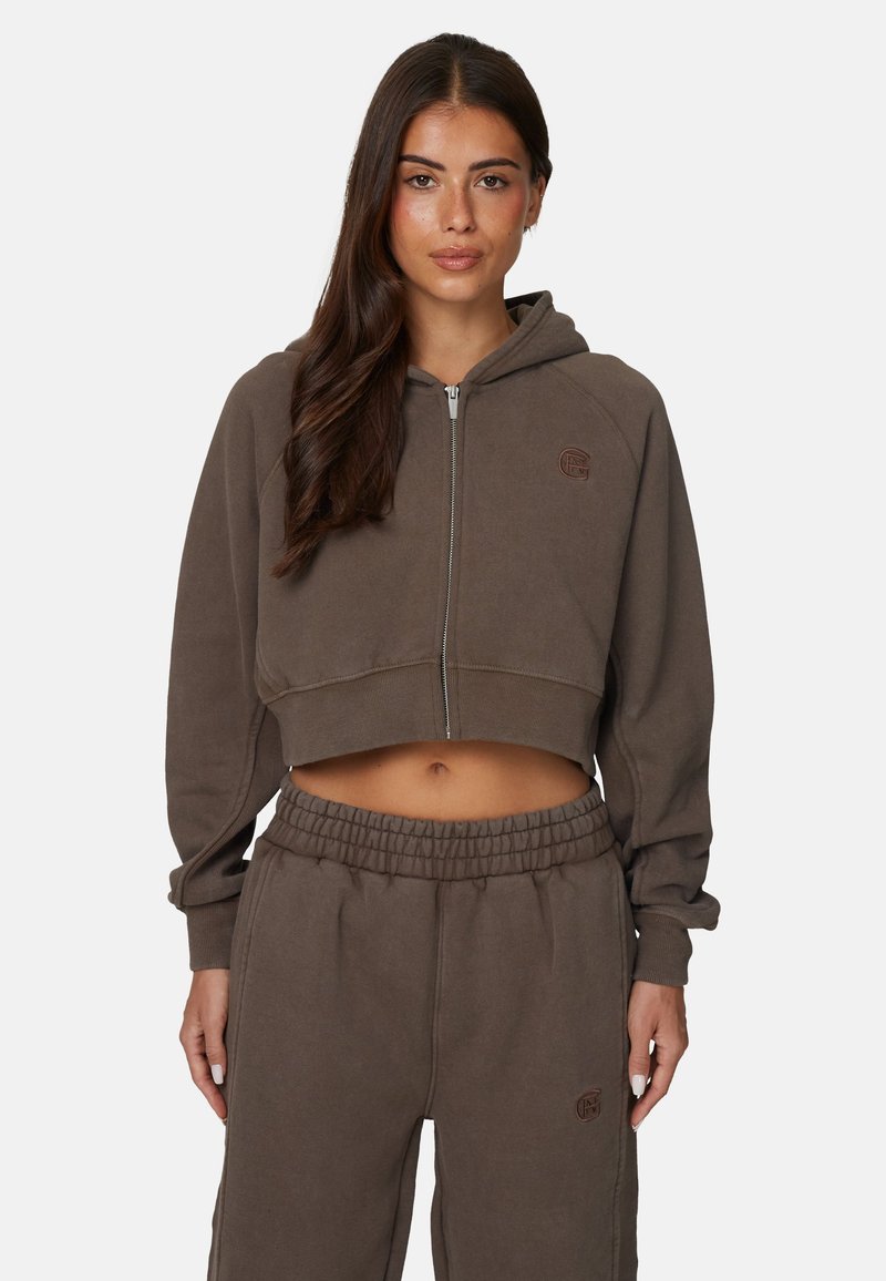 Hoodie marron cropped avec zip à l'avant, ourlet côtelé et détail de logo, associé à un pantalon de jogging assorti avec une taille élastique.