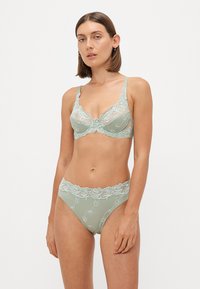Lingerieset in zachtgroen gaas met bloemige kantafwerking. Beha heeft een beugel en verstelbare bandjes; slip heeft een bijpassende kant tailleband en accenten.