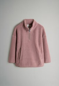Luddig, ljusrosa fleece-tröja med krage, halv-lång dragkedja och två sidofickor. Mjuk textur och oversize passform.