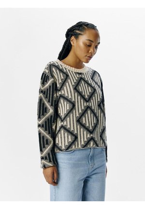 Knit sweater featuring a geometric black and beige pattern, round neckline, long sleeves, and a relaxed fit. Distressed texture at cuffs.