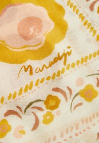 Floral fabric featuring yellow and pink flowers on a light background with a textured pattern. The design includes handwritten text.