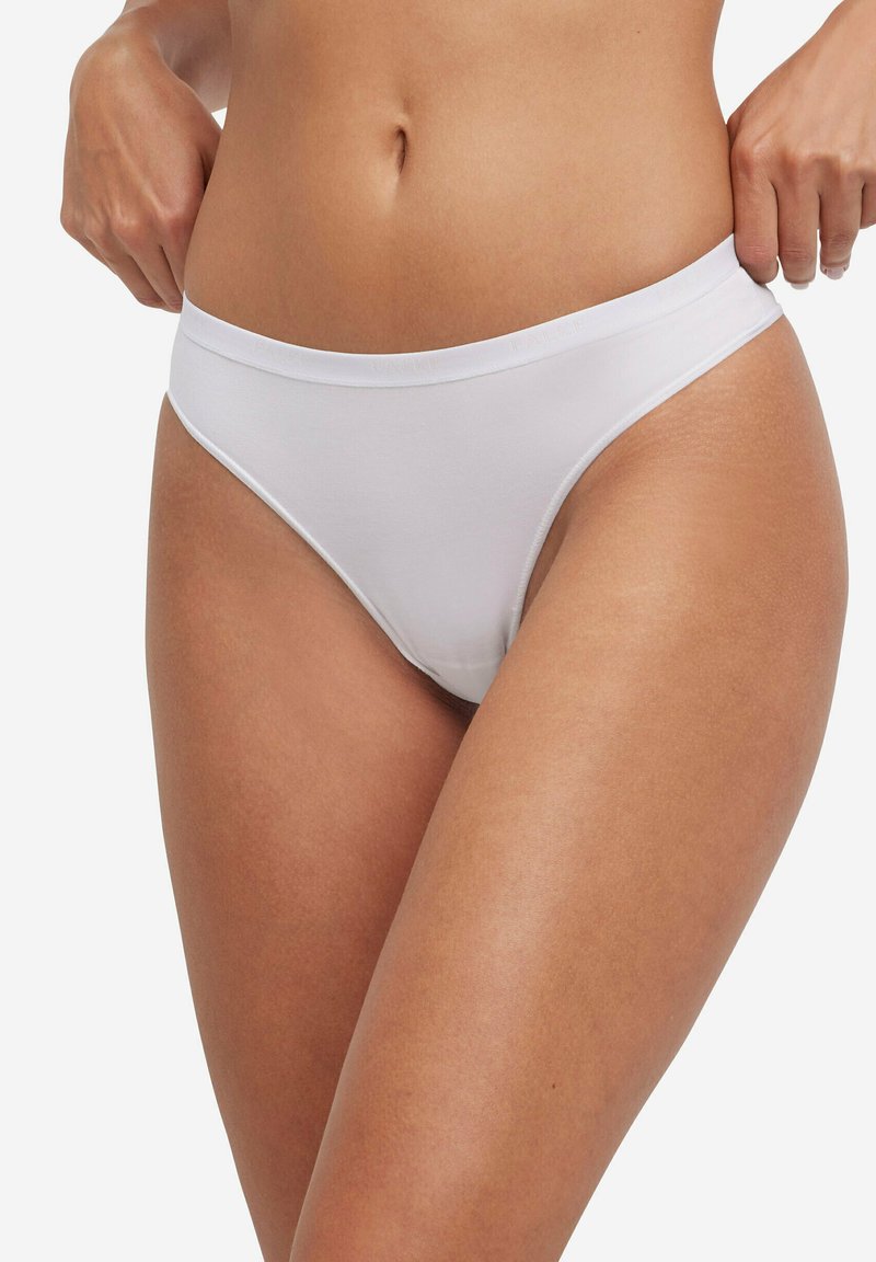 Slip bikini bianchi in cotone con una sottile fascia elastica in vita. Design senza cuciture e copertura moderata. Texture morbida e liscia.