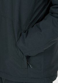 Svart vattenavvisande jacka med hög krage, dragkedjeförsedd sidoficka och textil med matt yta. Designen har en lös passform.