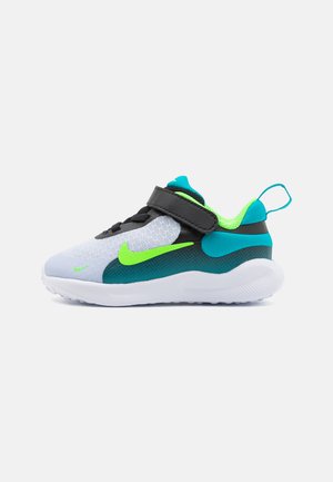 Baskets Nike pour tout-petits avec une tige en maille grise, accents turquoise et vert néon, bande velcro et semelle extérieure en caoutchouc blanche.