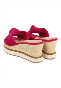 Sandalias de cuña de tela fucsia con un diseño anudado, que presentan un tacón de yute trenzado y una suela media blanca en contraste. Textura de suela lisa.