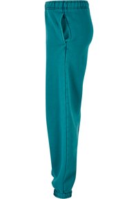 Teal joggebukser laget av myk stoff, med elastisk midje, sidelommer og innsnevrede mansjetter for en avslappet passform.