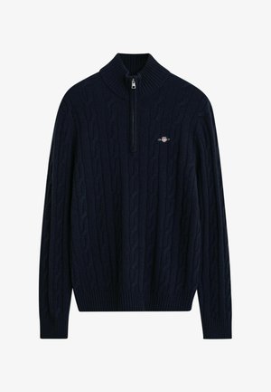 Middengrijze kabelgebreide trui met een hoge kraag en een halve rits. Bevat geribde manchetten en onderrand, gemaakt van zachte gebreide stof. Logo op de borst.