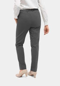 Grijze op maat gemaakte broek met een elastische tailleband, voorzien van een slim fit en rechte benen, gecombineerd met beige hoge hakken.