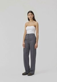 Gray tailored trousers with a high waist, side pockets, and a straight-leg design, paired with a fitted white strapless top.