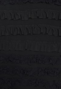 Mustavaksi kankaaksi, jossa on teksturoituja vaakaraitoja rypytystä ja pitsiä. Kankaassa on vaihtelevaa läpinäkyvyyttä ja peittäviä materiaaleja.