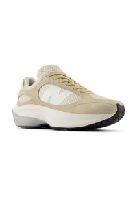 Beige sportcipő, velúr és hálós felsőrésszel, fehér logóval, kerek orral és struktúrált fekete gumitalppal.