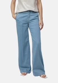 Světle modré džíny s širokými nohavicemi a vysokým pasem, z denimu, s jemnou texturou a klasickým designem pěti kapes, doplněné o reflexní top.
