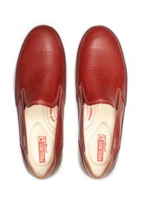 Zapatos rojos tipo slip-on con un upper de cuero texturizado, punta redondeada, acentos de elástico en los laterales y una plantilla acolchada, con una suela de goma blanca.