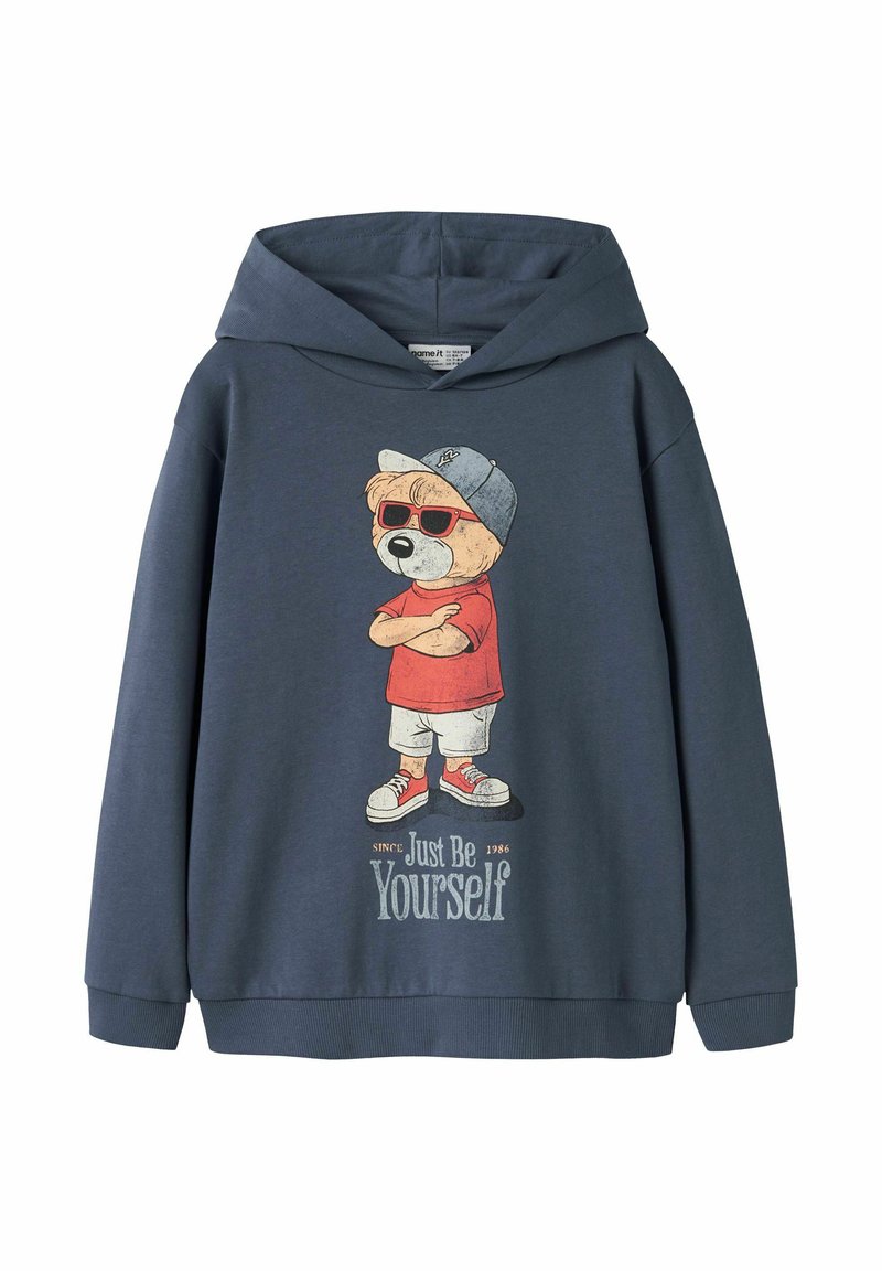Felpa con cappuccio blu navy con grafica frontale di un orso che indossa occhiali da sole, cappello, maglietta rossa, pantaloncini, scarpe da ginnastica e la scritta "Just Be Yourself."