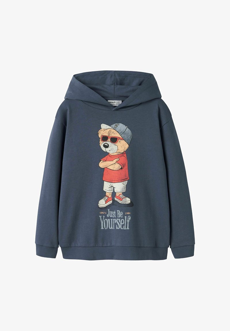 Felpa con cappuccio blu navy con grafica frontale di un orso che indossa occhiali da sole, cappello, maglietta rossa, pantaloncini, scarpe da ginnastica e la scritta "Just Be Yourself."