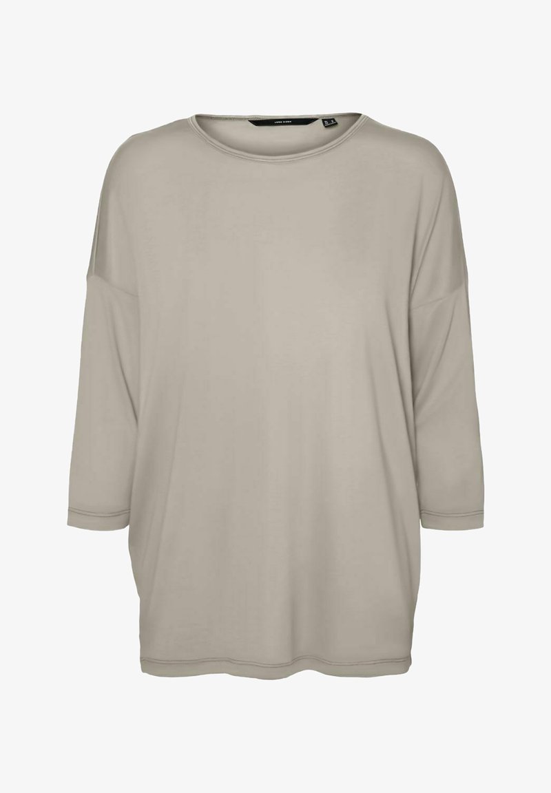 T-shirt oversize beige clair en tissu doux, avec un col rond et des manches trois-quarts. Texture lisse sans motifs apparents.