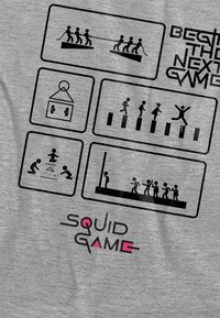 Gray t-shirt featuring black graphic illustrations of game scenarios and the text "SQUAD GAME" in black and pink. Clear, bold design elements.