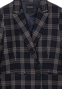 Blazer navy con motivo a quadri in bianco e ruggine. Presenta due bottoni, rever a punta e una fodera interna liscia. Taglia S.