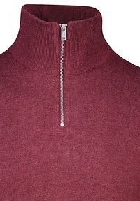 Sweater bordeaux con zip e collo alto, caratterizzato da una texture a coste. Presenta una zip argentata nella parte anteriore per una chiusura regolabile.