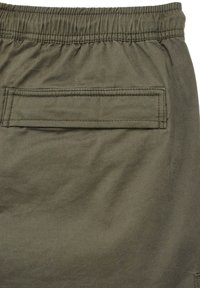 Shorts vert olive avec une taille élastique et une poche arrière avec rabat. Fabriqués en tissu doux et durable avec une texture plate.