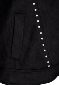 Veste en faux suede noir avec une poche latérale et des clous argentés le long de la couture pour plus de détails. Texture lisse et design ajusté.