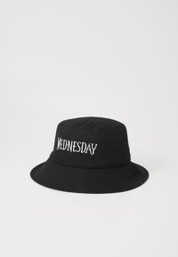 Chapeau noir en tissu avec un texte brodé blanc indiquant "WEDNESDAY" sur le devant. Couronne arrondie et large bord.