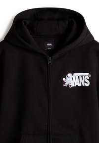 Sudadera negra con cremallera hecha de un tejido suave, que presenta un logo de Vans blanco con un detalle gráfico colorido en el lado izquierdo del pecho.