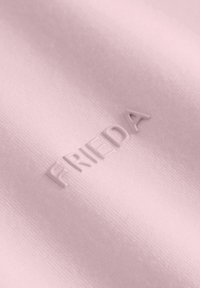 Jasnoróżowa tkanina z wytłoczonym napisem "FRIEDA", o gładkiej fakturze i subtelnym połysku.