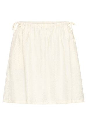 Jupe blanche longueur genou avec taille élastique et liens latéraux, présentant un motif texturé subtil sur un tissu léger.