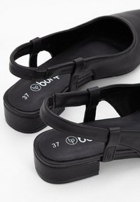 Scarpe slingback in pelle nera con tacco piatto. Tra le caratteristiche ci sono cinturini regolabili, punta affusolata e soletta imbottita marcata "37".